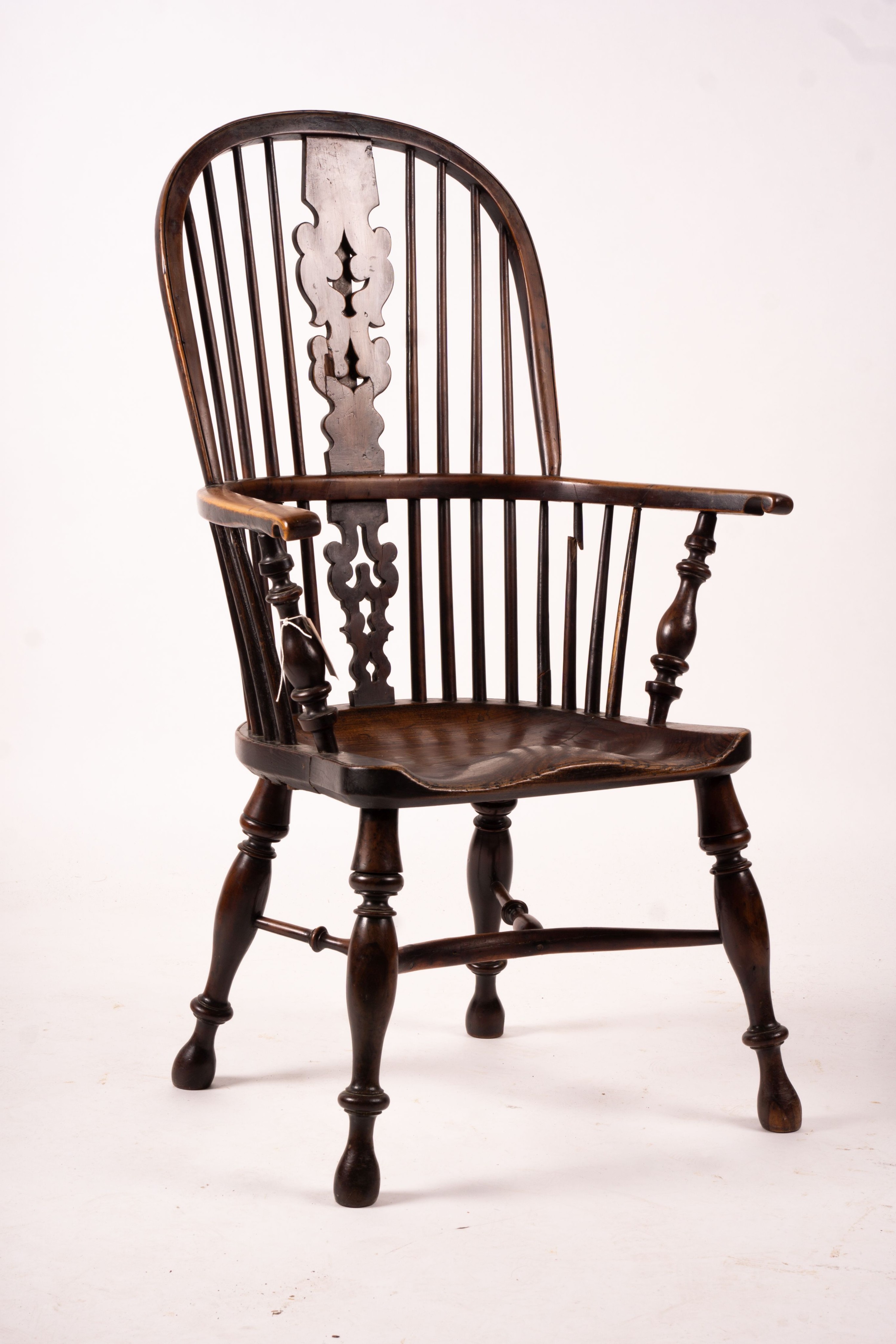 A mid 19th century yew and elm Yorkshire area Windsor armchair with saddle-seat and crinoline stretcher, width 63cm, depth 47cm, height 110cm